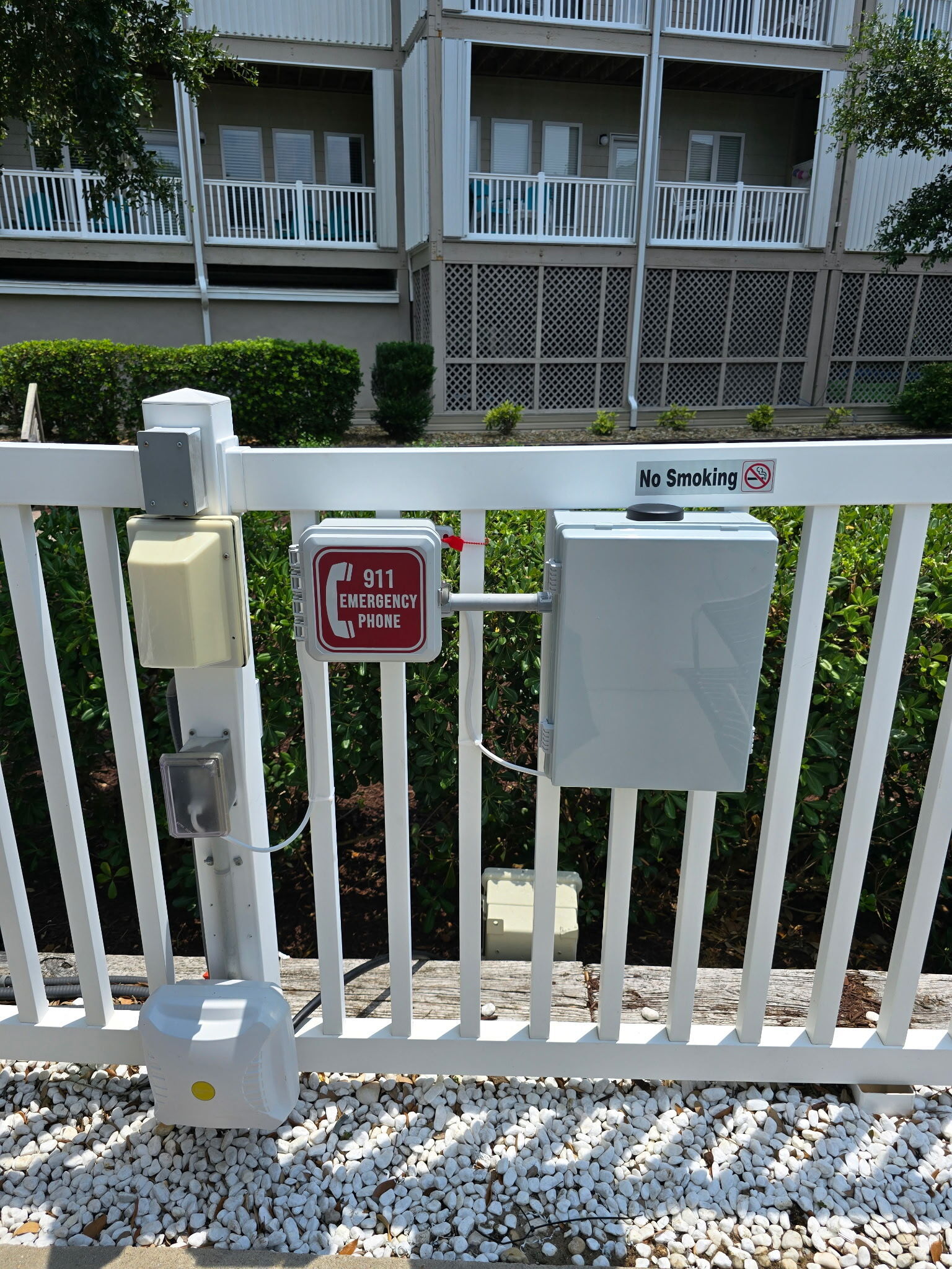 Outdoor pool emergency phone installation featuring a weatherproof enclosure and PVC conduit designed to protect communication cabling from the elements.